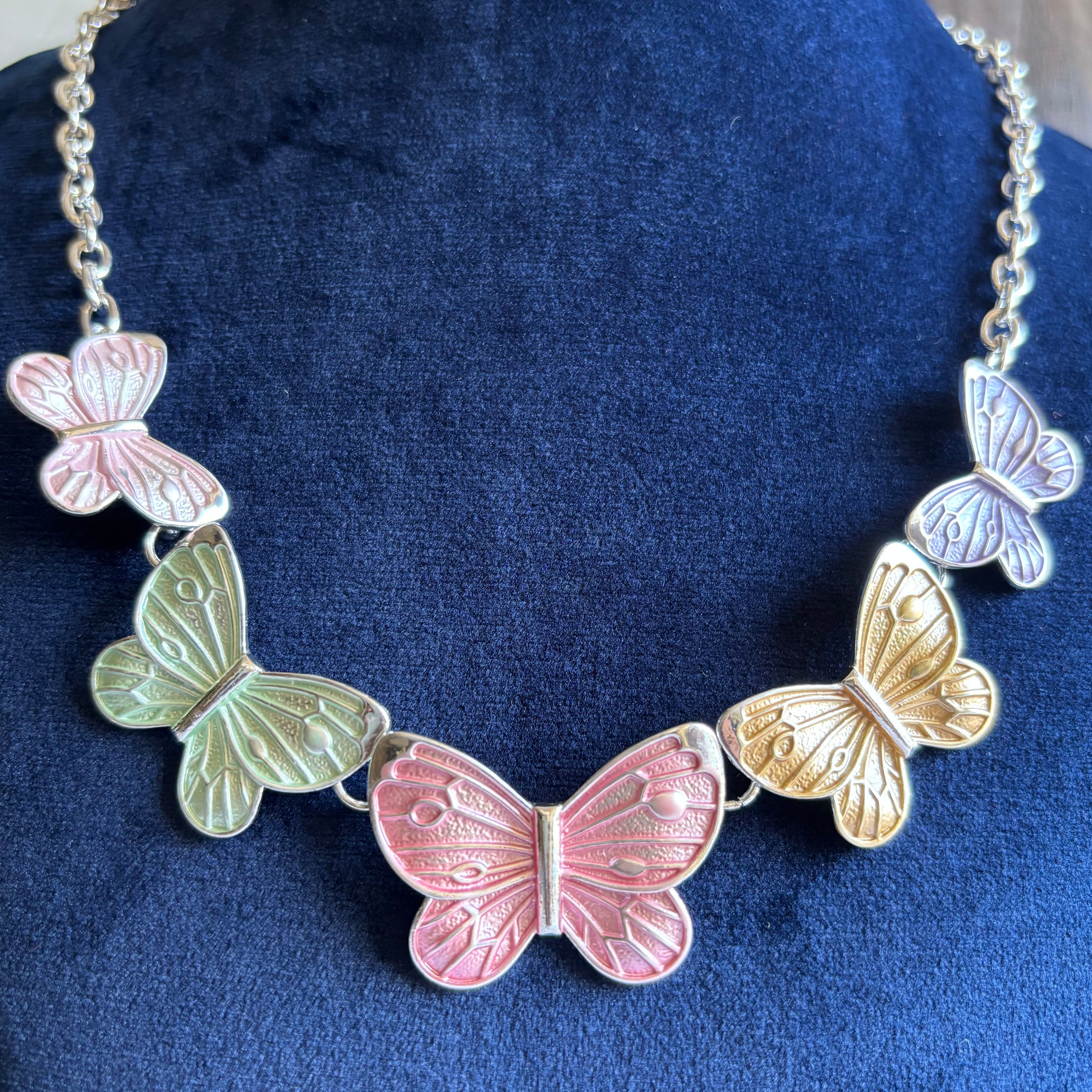 Butterfly necklace with multicolored butterflies on a blue velvet background